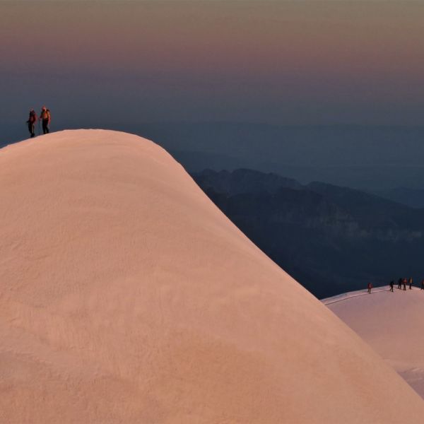 Climbers on the summit of Mont Blanc at sunrise.