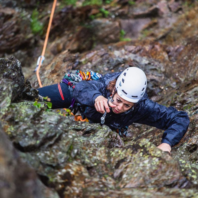 Climber placing protection on a trad route in Chamonix Alps