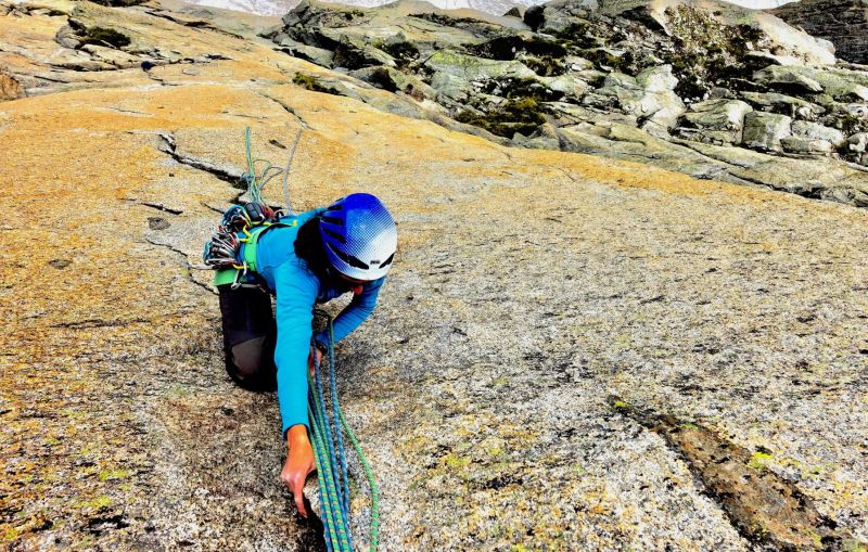 Climbing a crack route and removing the protection on a multi-pict granite route in Chamonix