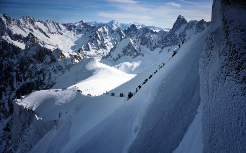 skiers descending the Aiguille du Midi ridge secured by Vallee Blanche ski guides