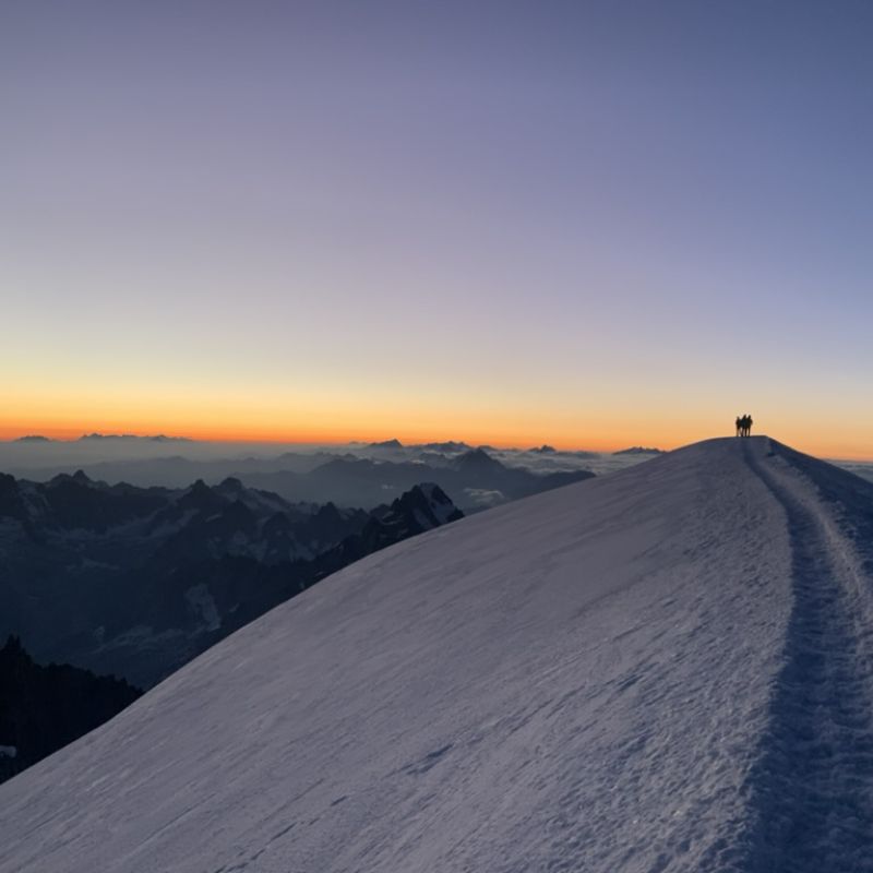 Climbers on the summit of Mont Blanc at sunrise.